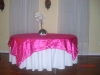 Round table with dark pink linen